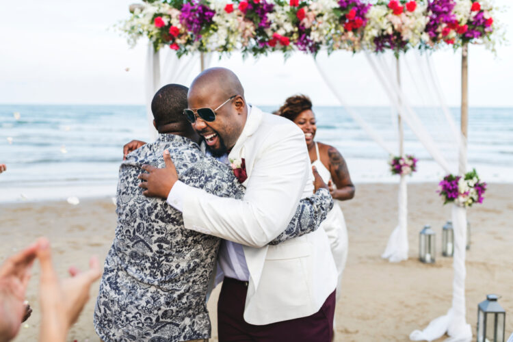 African american friends hug at a destination wedding