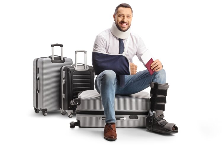 Man with broken arm sitting on suitcases
