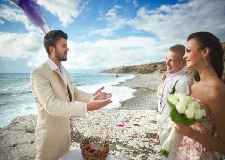 Preacher at a destination wedding confers with the bride and groom