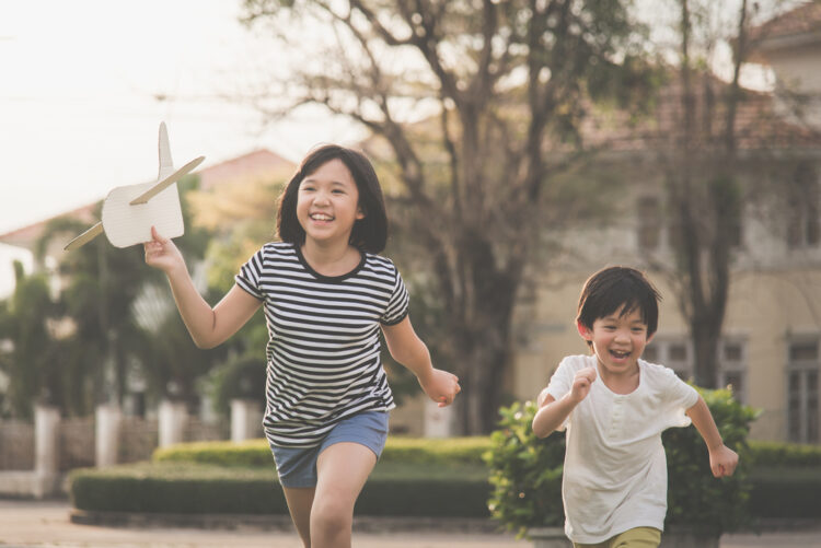 Two children running through the park
