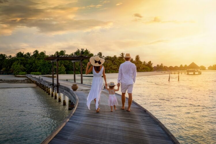 Couple walking on pier with child in the Maldives