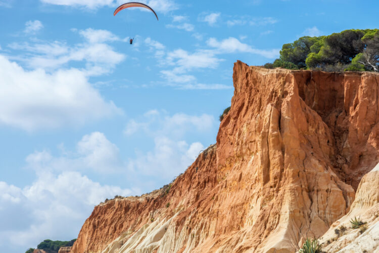 Cliffs and paragliders at the Praia de Falésia 