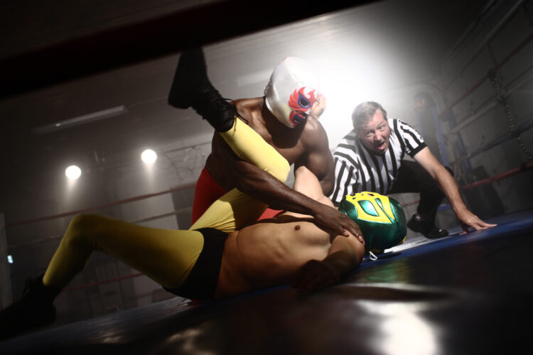 Masked wrestlers and referee in ring