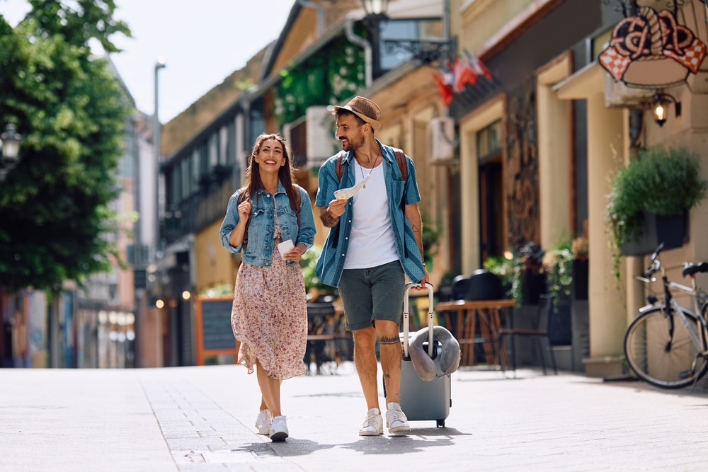 Couple strolling through town with suitcase