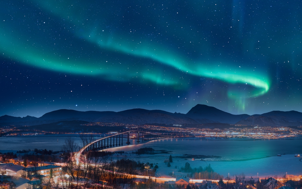 Aurora borealis or Northern lights in the sky over Tromso with Sandnessundet Bridge