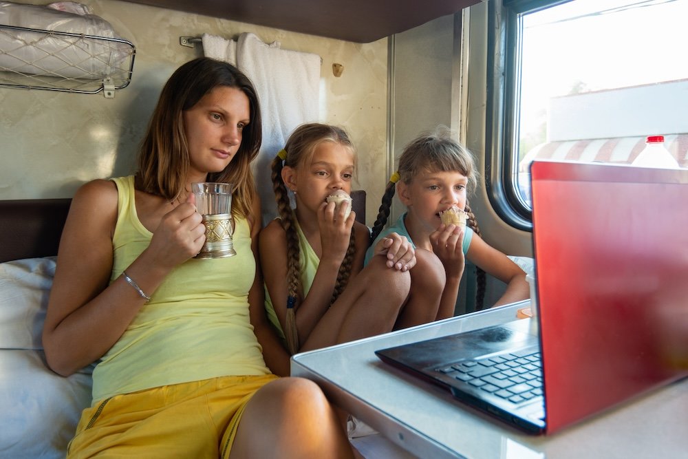 Family in sleeper car watching video on computer